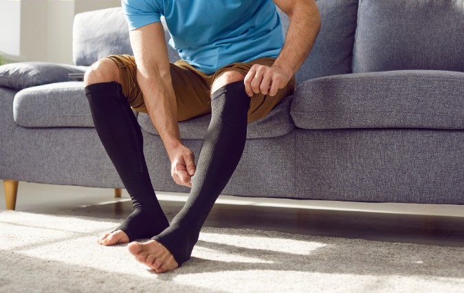 Patient putting on compression stockings